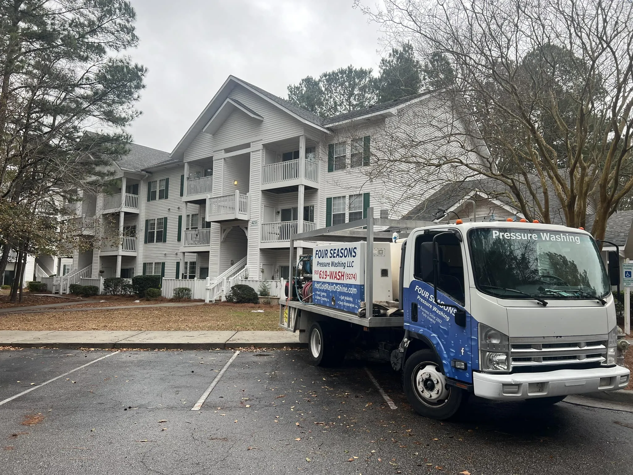 power-washing-truck-rear-equipment-view-at-residential-driveway-on-asphalt-road-wilmington-nc