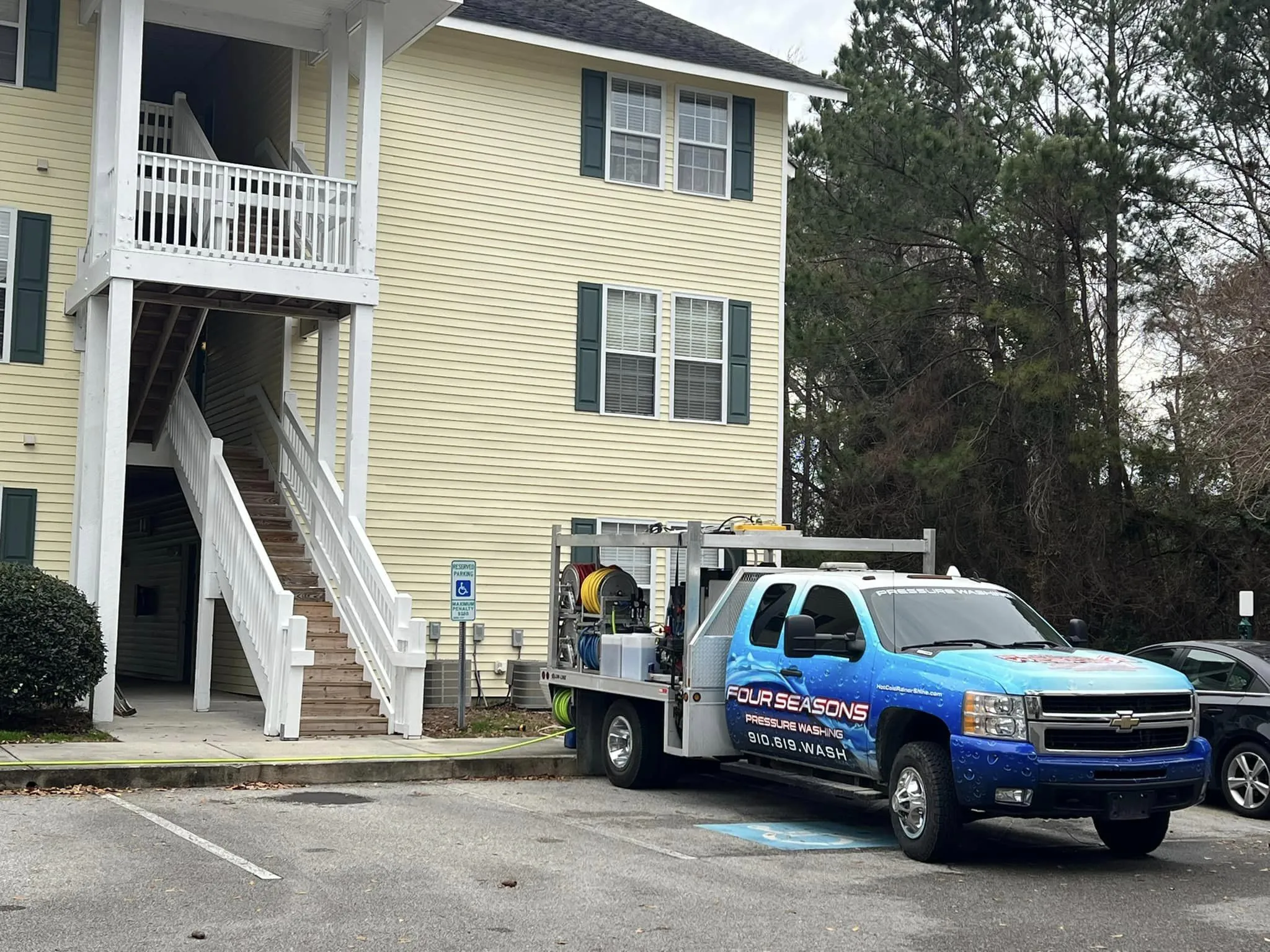 power-washing-truck-side-profile-view-at-residential-driveway-next-to-sidewalk-wilmington-nc